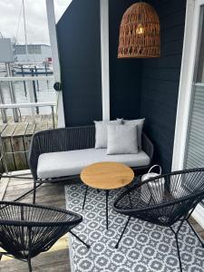 een patio met een bank en een tafel en stoelen bij Hausboot Koje INE Huus & Meer in Ortmühle +9 foto's