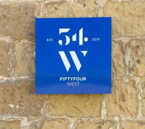 a blue phosphorus sign on a brick wall at Fiftyfour West Boutique Living in Għarb