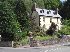 ein großes weißes Haus mit einer Steinmauer in der Unterkunft Inglewood House in Monmouth