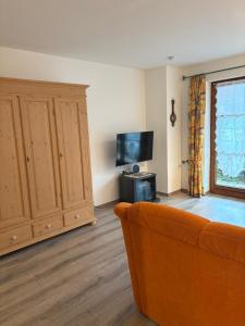 a living room with a couch and a flat screen tv at Ferienwohnung Eulennest in Bolsterlang