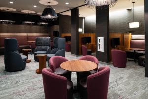 a waiting room with chairs and tables and a waiting room at Courtyard Charlotte Steele Creek in Charlotte +24 photos