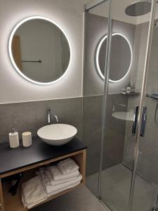 a bathroom with a sink and a glass shower at Ustreia Orta in Lohn +50 photos