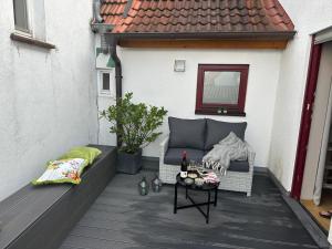 a patio with a couch and a table on a balcony at Downtown No 3 in Bad Soden-Salmünster