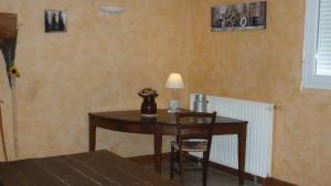 einen Tisch mit einer Lampe und einem Stuhl in einem Zimmer in der Unterkunft Gîte de Pailherols in Pailherols