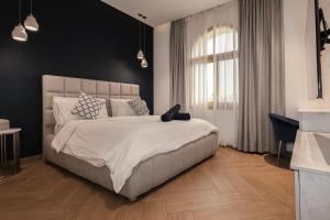 a bedroom with a large bed with a black wall at Luxurious Villa 5BHK with Pool BBQ and Full Time Housemaid Assistance - live in in Dubai