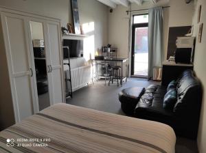 a room with a bed and a couch and a kitchen at "Arends nest" in Heers