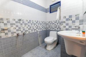 a bathroom with a toilet and a sink at Marari ShangriLa Vecation Stay in Alleppey +2 photos