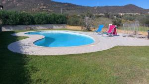 una pequeña piscina con 2 sillas en un patio en VILLA ELEONORA-IUN-P6104, en San Teodoro