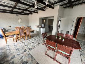 a living room with a wooden table and chairs at Rural Villa Guesthouse in Naledi