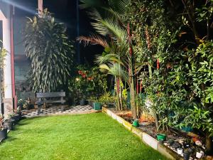 a garden with a bench and trees and plants at Moonstone Holiday Cottages in Badulla