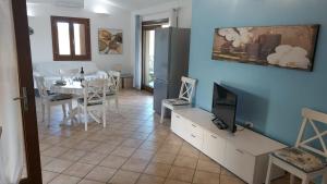 Una sala de estar con televisión y un comedor. en VILLA ELEONORA-IUN-P6104, en San Teodoro