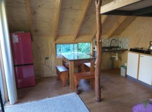 a kitchen with a table in a tiny house at Refugio y Tinaja Curiñanco in Valdivia