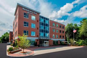 a red brick building with an american flag in front of it at Residence Inn by Marriott Boston Bridgewater in Bridgewater