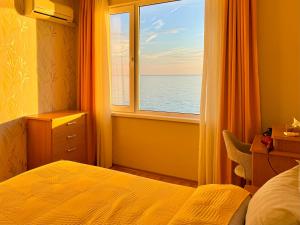 a bedroom with a window with a view of the ocean at Beachfront Havana in Sveti Vlas