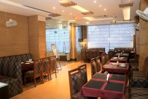 a dining room with tables and chairs in a restaurant at Modi Hotel & Resorts in Pinjaur
