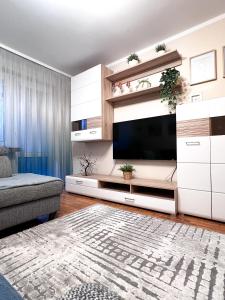 a living room with a large television and a couch at Apartament Sieroszewskiego in Puławy