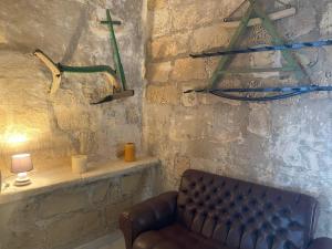 a living room with a couch and a wall with weapons at Fiftyfour West Boutique Living in Għarb