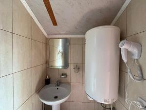 Un baño pequeño con lavabo y espejo. en Котедж Краєвид, en Yablunytsya