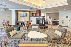 a hotel lobby with chairs and a fireplace at Residence Inn by Marriott Woodbridge Edison/Raritan Center in Woodbridge