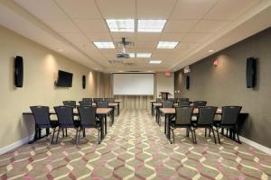 a conference room with tables and chairs and a whiteboard at Residence Inn by Marriott Woodbridge Edison/Raritan Center in Woodbridge +23 photos