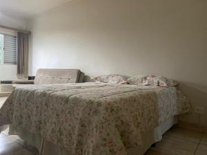 サン・ビセンテにあるApto 18 - Pé na areia, Santosのベッドルーム1室(毛布、椅子付)