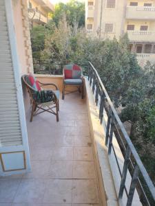 un balcon avec deux chaises et un banc dans l'établissement Fun house, à Ain Sokhna