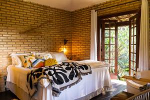 a bedroom with a bed and a brick wall at Solar Maria Carolina in Mario Campos +71 photos