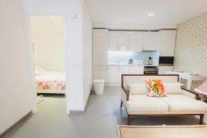 a living room with a couch and a kitchen at Loving Chiado in Lisbon