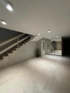 Habitación grande y vacía con escalera en un edificio en פנינת רעננה, en Raanana 16 fotos más