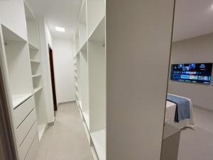 a walk in closet with white shelving at Casa em Vilas 70m da Praia in Lauro de Freitas +32 photos