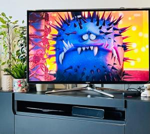 a flat screen tv sitting on top of a cabinet at Apartament z ogródkiem, blisko centrum in Zielona Góra