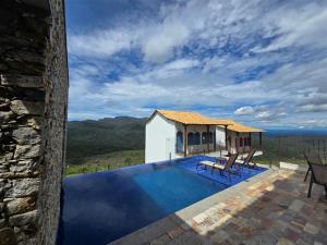 a house with a swimming pool next to a building at La Villa Novas Pousada in Lavras Novas