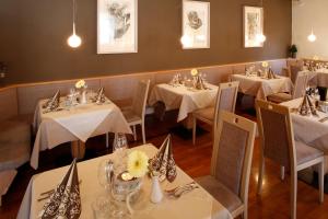 レージアにあるHotel Am Reschenseeの白いテーブルクロスのテーブルと椅子が備わるレストラン