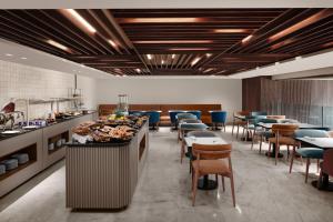 a restaurant with a buffet with tables and chairs at Courtyard by Marriott Casablanca Downtown in Casablanca