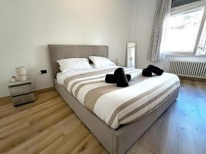 a large bed in a bedroom with a wooden floor at Isola Holiday in Feltre