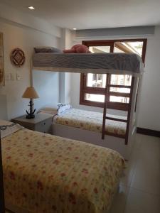 a bedroom with two bunk beds and a window at Cancún Praia do Forte in Mata de Sao Joao