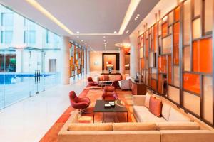 a lobby with a couch and chairs and a pool at Courtyard by Marriott Kochi Airport in Nedumbassery
