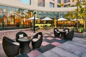 a group of chairs and tables in front of a building at Courtyard by Marriott Kochi Airport in Nedumbassery