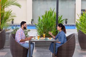 a man and woman sitting at a table in a restaurant at Courtyard by Marriott Kochi Airport in Nedumbassery