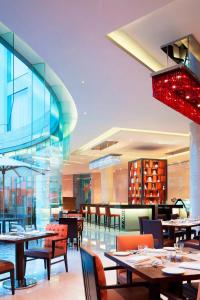 a restaurant with tables and chairs and a glass wall at Courtyard by Marriott Kochi Airport in Nedumbassery