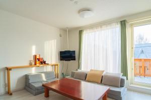 a living room with a couch and a table at Niseko Yu Villa B in Niseko