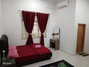 a bedroom with a red bed and a window at Redhousehomestay in Kota Bharu +36 photos