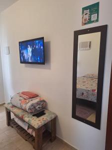 a mirror and a stool in a room with a mirror at Studio Nosso Sonho in Cabo Frio +23 photos