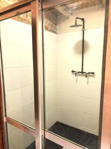 a shower with a glass door in a bathroom at La Fabrica in Yacanto