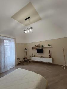 a white bedroom with a bed and a television at A Casa di Nonna Maria in Roccapiemonte