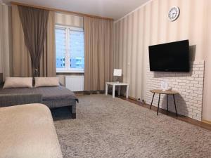 a hotel room with a bed and a flat screen tv at UpTown-Квартира in Vyshhorod
