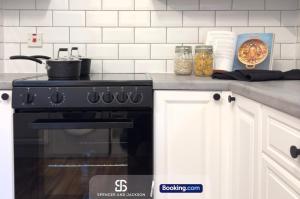 a kitchen with a stove and a counter top at 2 Bedroom Spacious Duplex with Free Parking Near The University - By Spencer & Jackson Short Lets & Serviced Accommodation Oxford in Oxford