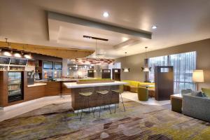 a large kitchen with a bar and a living room at Courtyard by Marriott Charlotte Airport LoSo in Charlotte