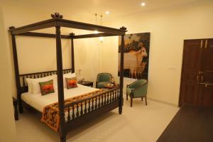 a bedroom with a canopy bed and a chair at The Grand Imperial - Heritage Hotel in Agra