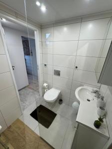 a white bathroom with a sink and a toilet at Domek na Kępce in Szczyrk +22 photos